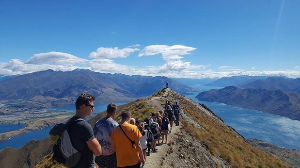 This image. posted on Reddit and captioned the "social media queue", shows a long line of hikers,...