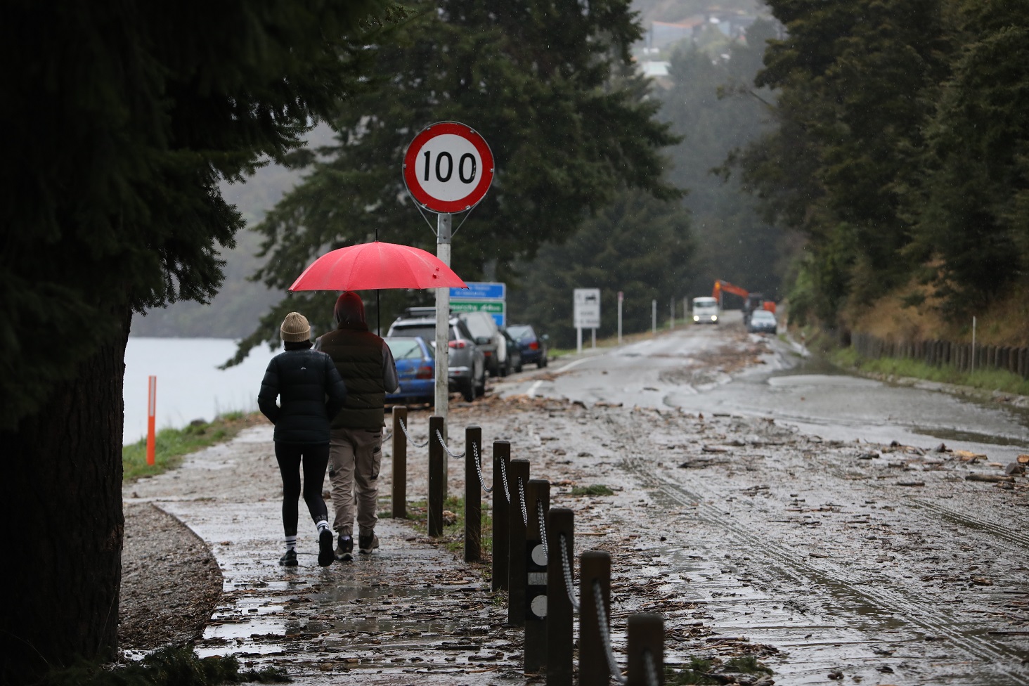 People pass by flood debris on a road in Queenstown last week. Photo: Rhyva van Onselen