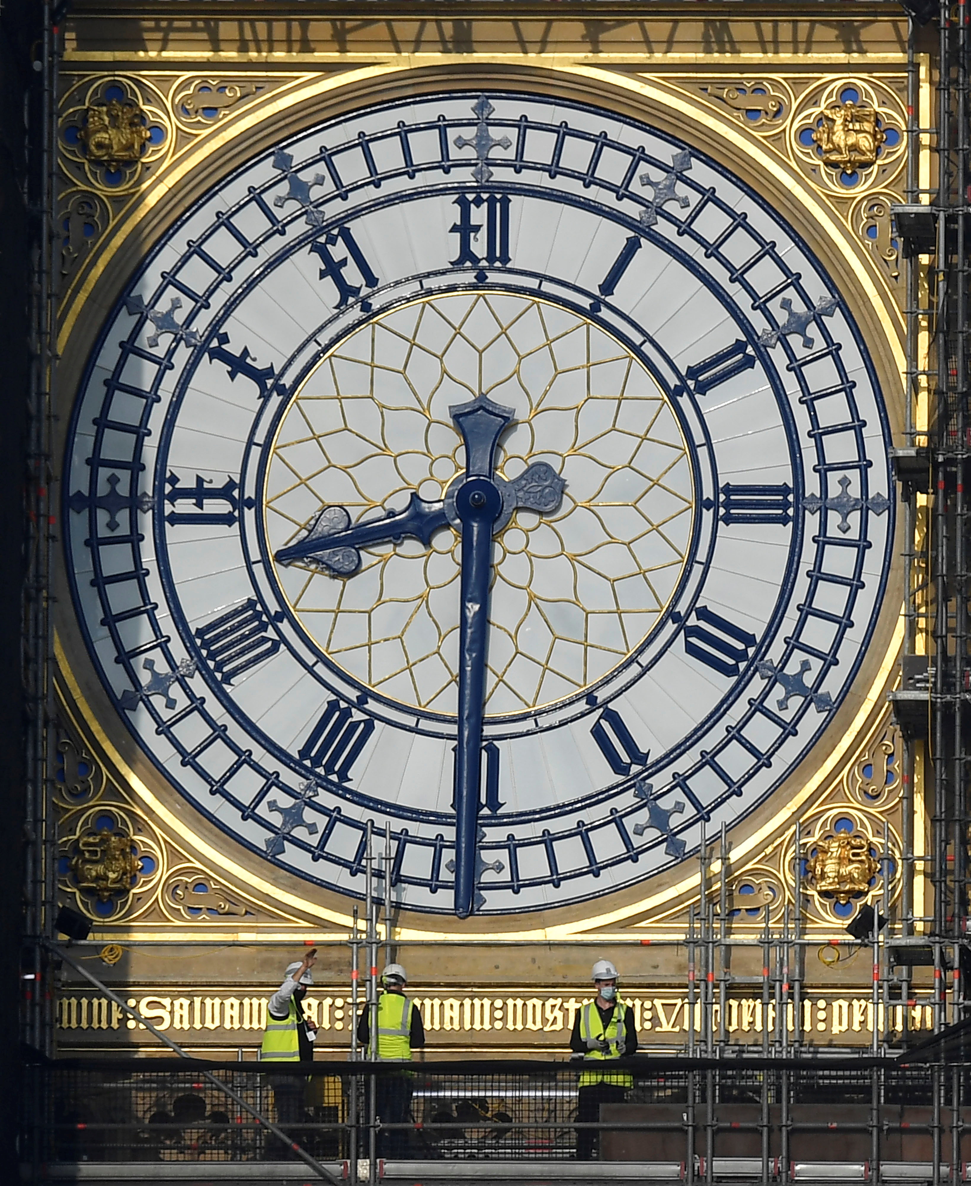 Workers stand on scaffolding underneath one of the clock faces on the Elizabeth Tower, more...