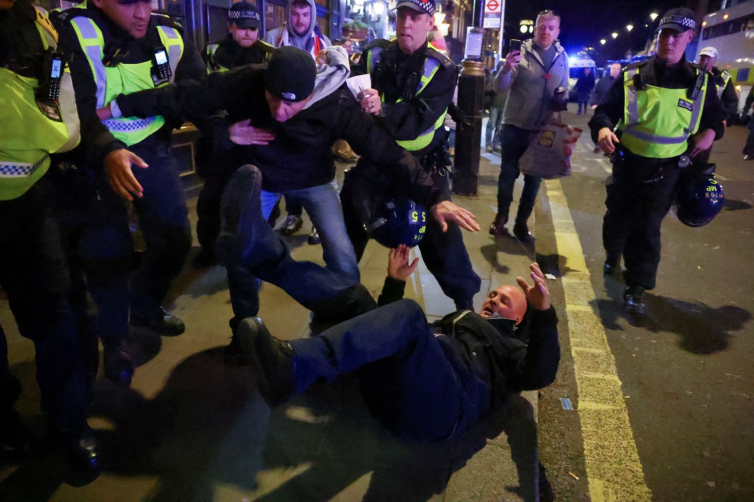 Police officers detain a counter-protester during the rally in London. Photo: Reuters