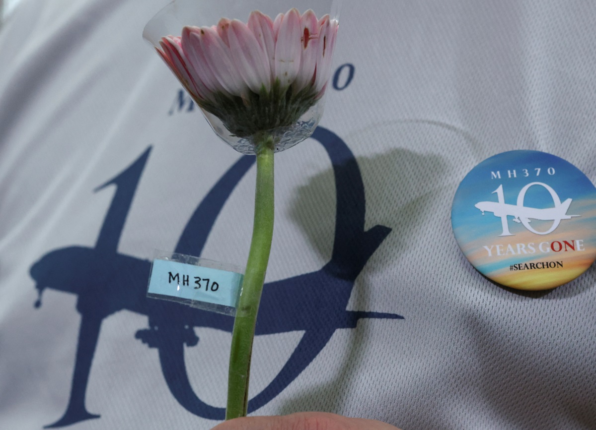 A person holds a flower during a remembrance event in Subang Jaya, Malaysia marking the 10th...