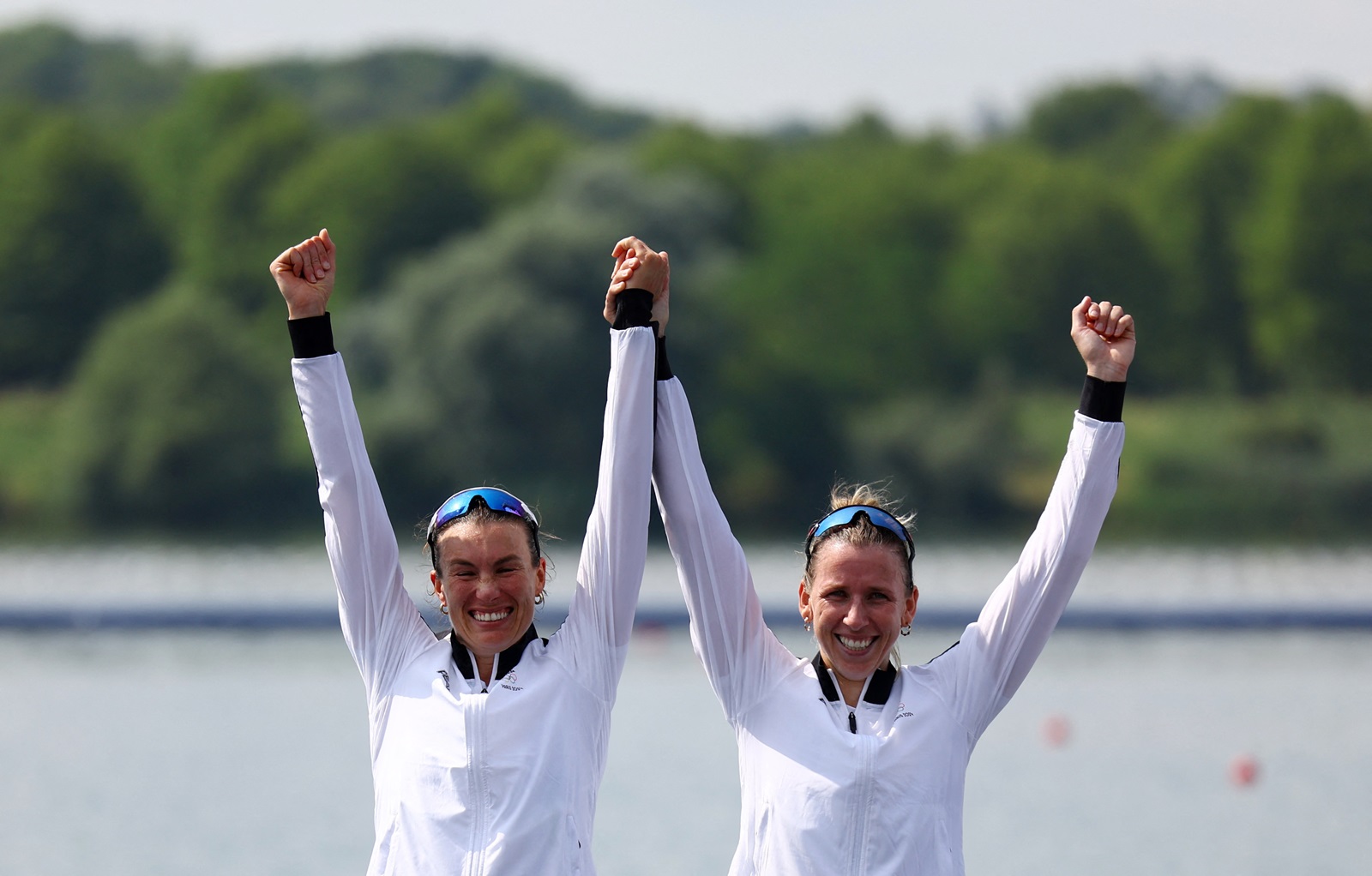 New Zealand's Brooke Francis and Lucy Spoors celebrate on the podium after winning gold in the...