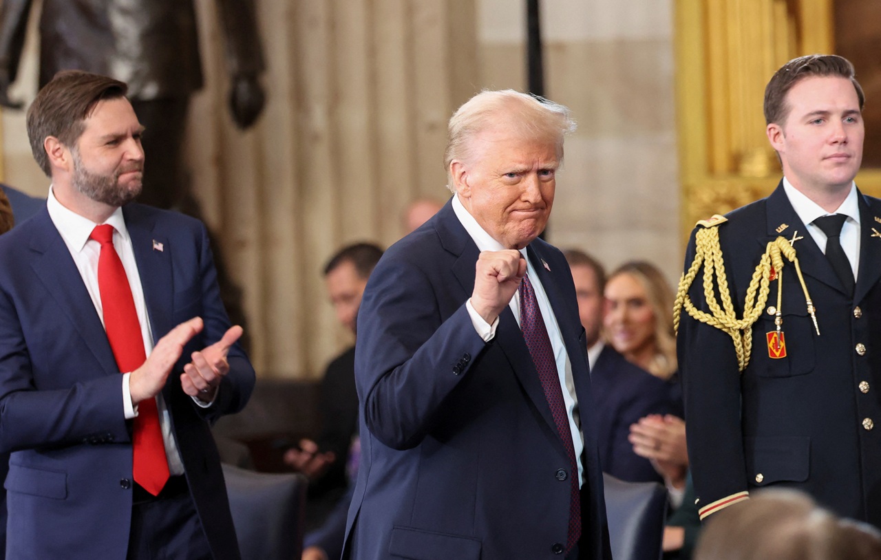 US Vice President J.D. Vance applauds as President Donald Trump gestures to the crowd during his...