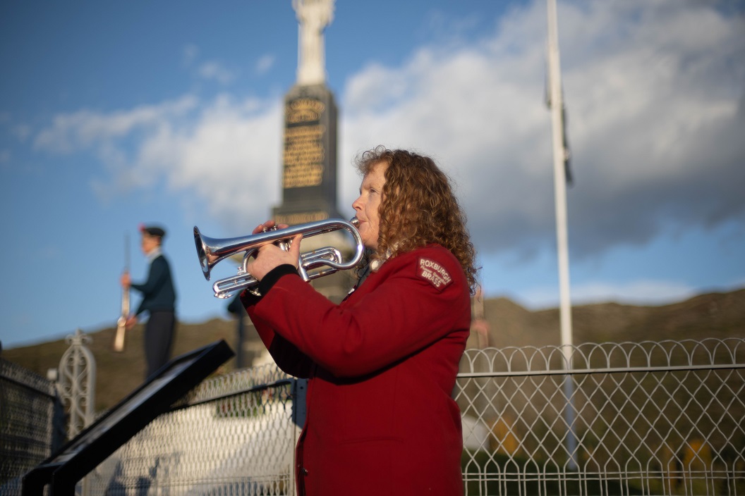 Christine Wright, of the Roxburgh Brass Band, plays 'Last Post' during the Anzac wreath-laying...