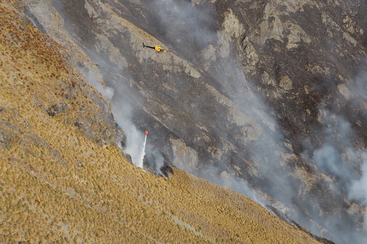 One of six helicopters working to contain the fire burning in steep terrain on Mt Creighton....