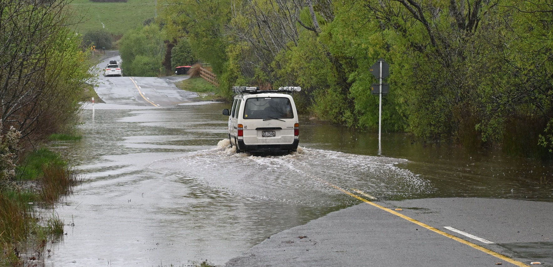 A van negotiates a flooded section of Old Brighton Rd near Fairfield in Dunedin on Thursday...