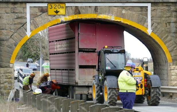 Emergency services work to dislodge the stock truck’s trailer from beneath the bridge. PHOTO:...