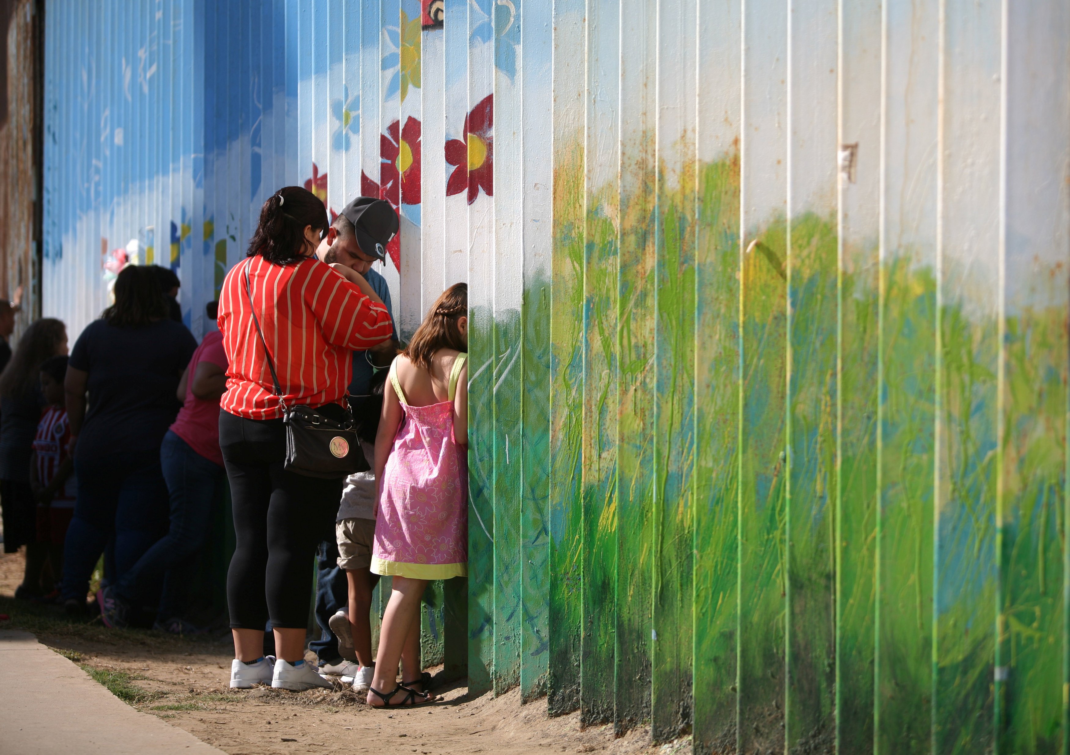 People talk to relatives at the border wall  dividing the US and Mexico in Tijuana. Photo: Reuters