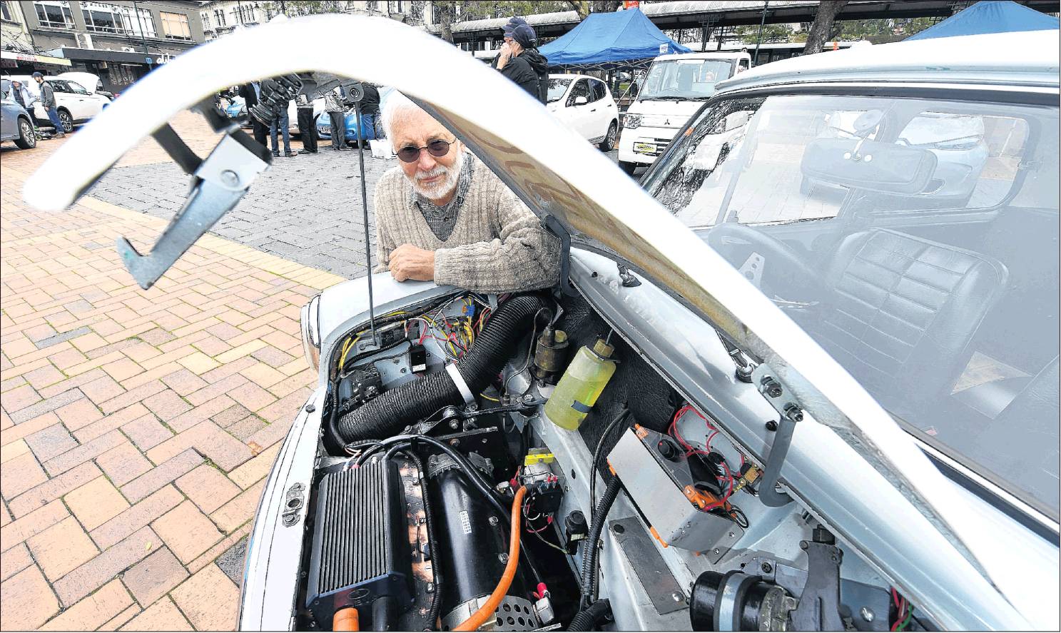 Michael Laba shows off his 1968 Morris Mini, which he converted to run on electricity in 1998, in...