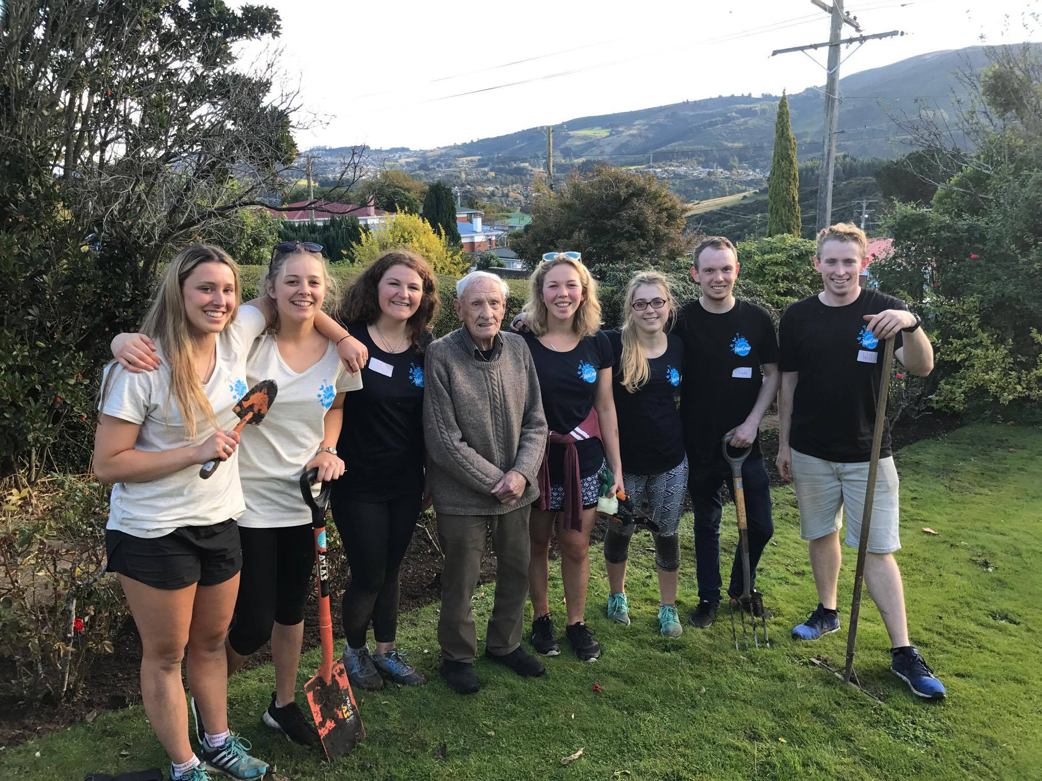 Dunedin man Vernon McArley stands in his yard with University of Otago student volunteers (from...