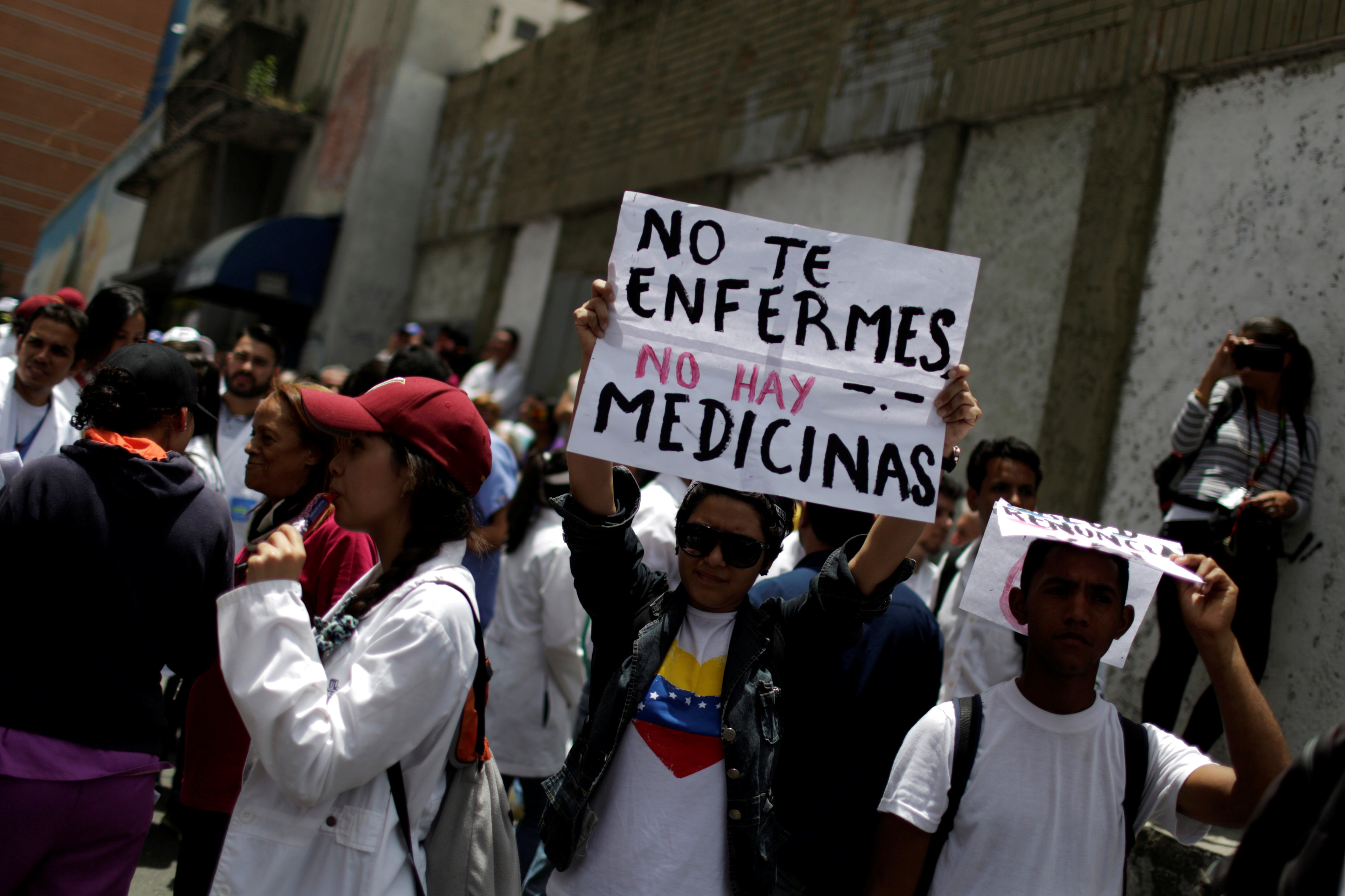 A woman held a banner reading "Do not get sick. There are no medicines" in a rally of health...