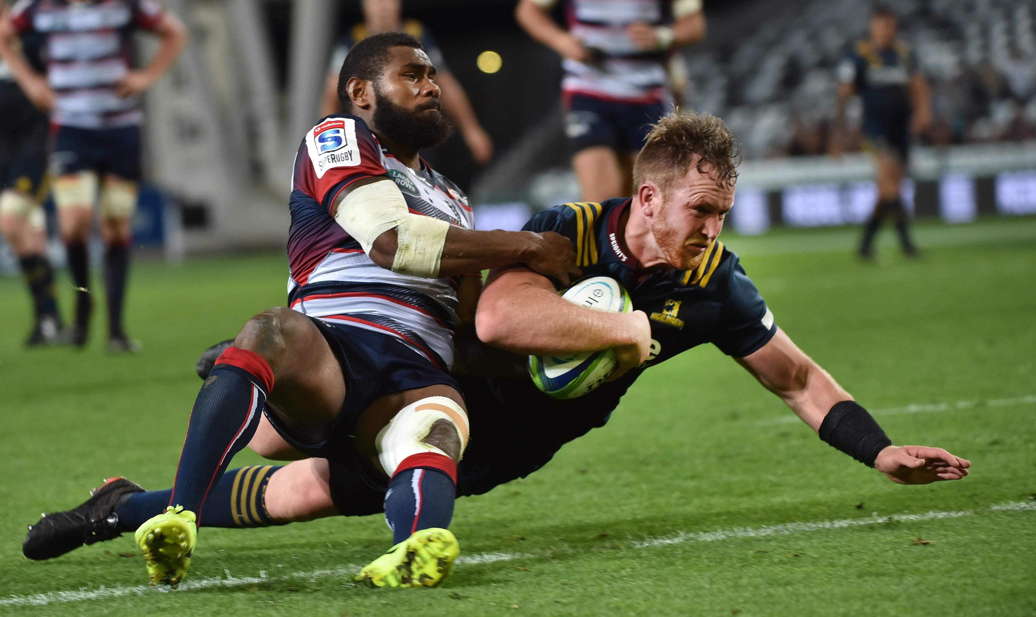 Highlander Gareth Evans goes over to score while tackled by Rebel Marika Koroibete at the Forsyth...