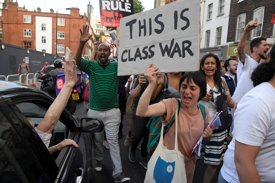 Demonstrators hold up banners during a march in Kensington two days after the fire. Photo Reuters
