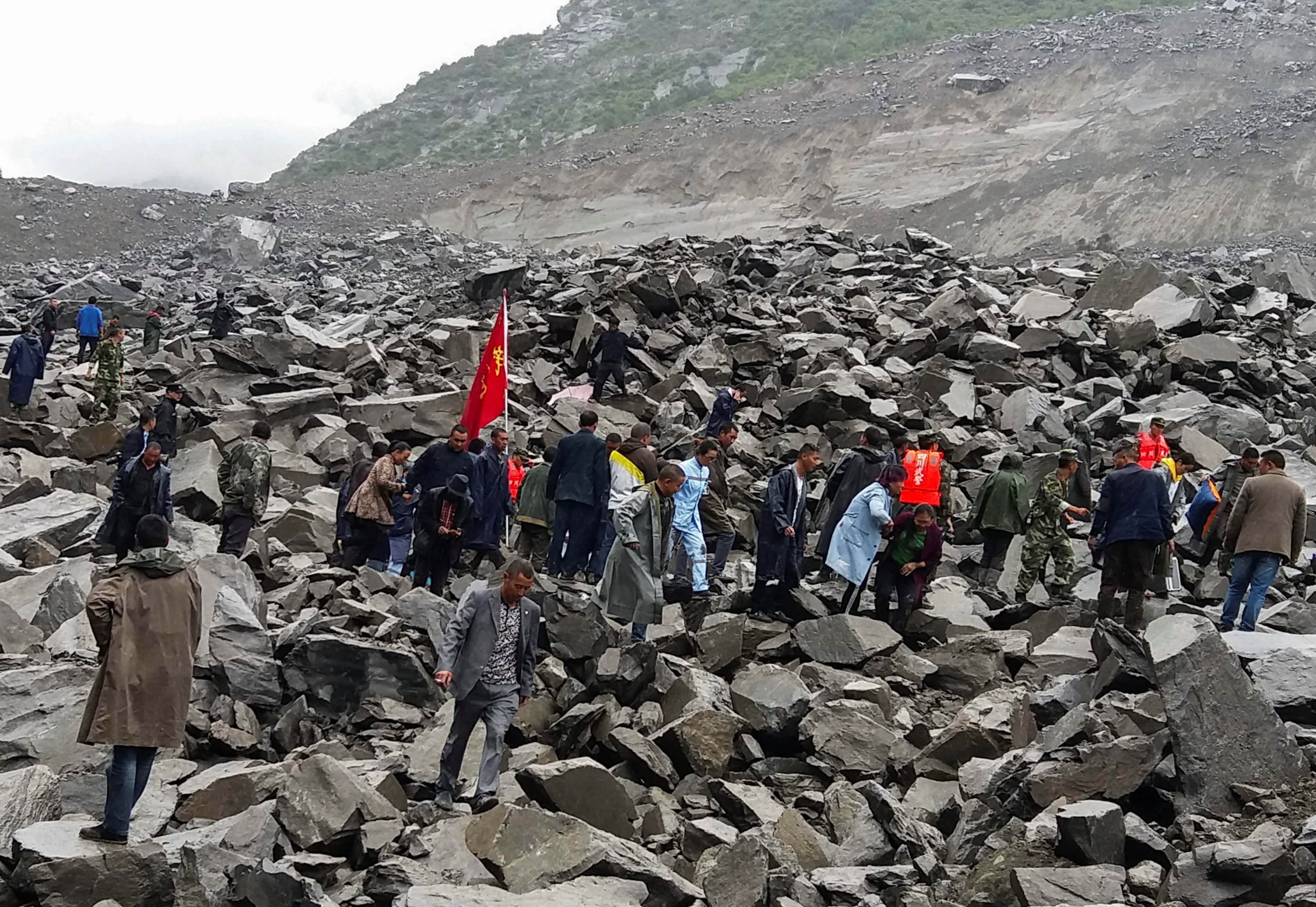 People search for survivors at the site of a landslide that destroyed some 40 households, where...