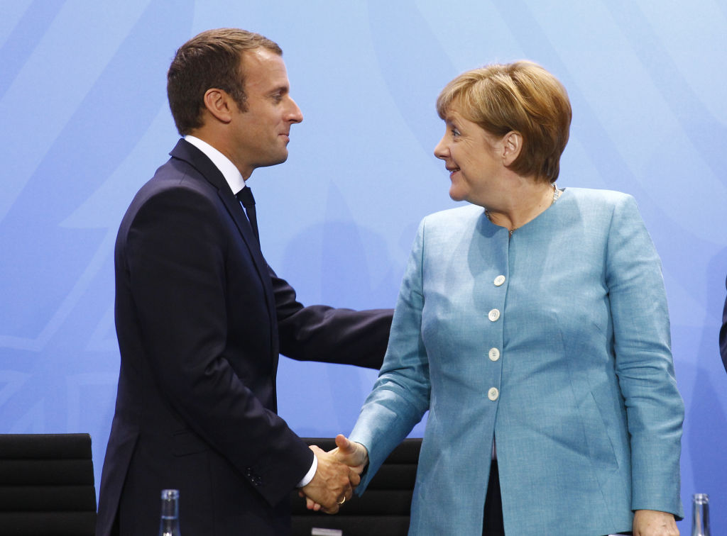 German Chancellor Angela Merkel and French President Emmanuel Macron shake hands after a Press...