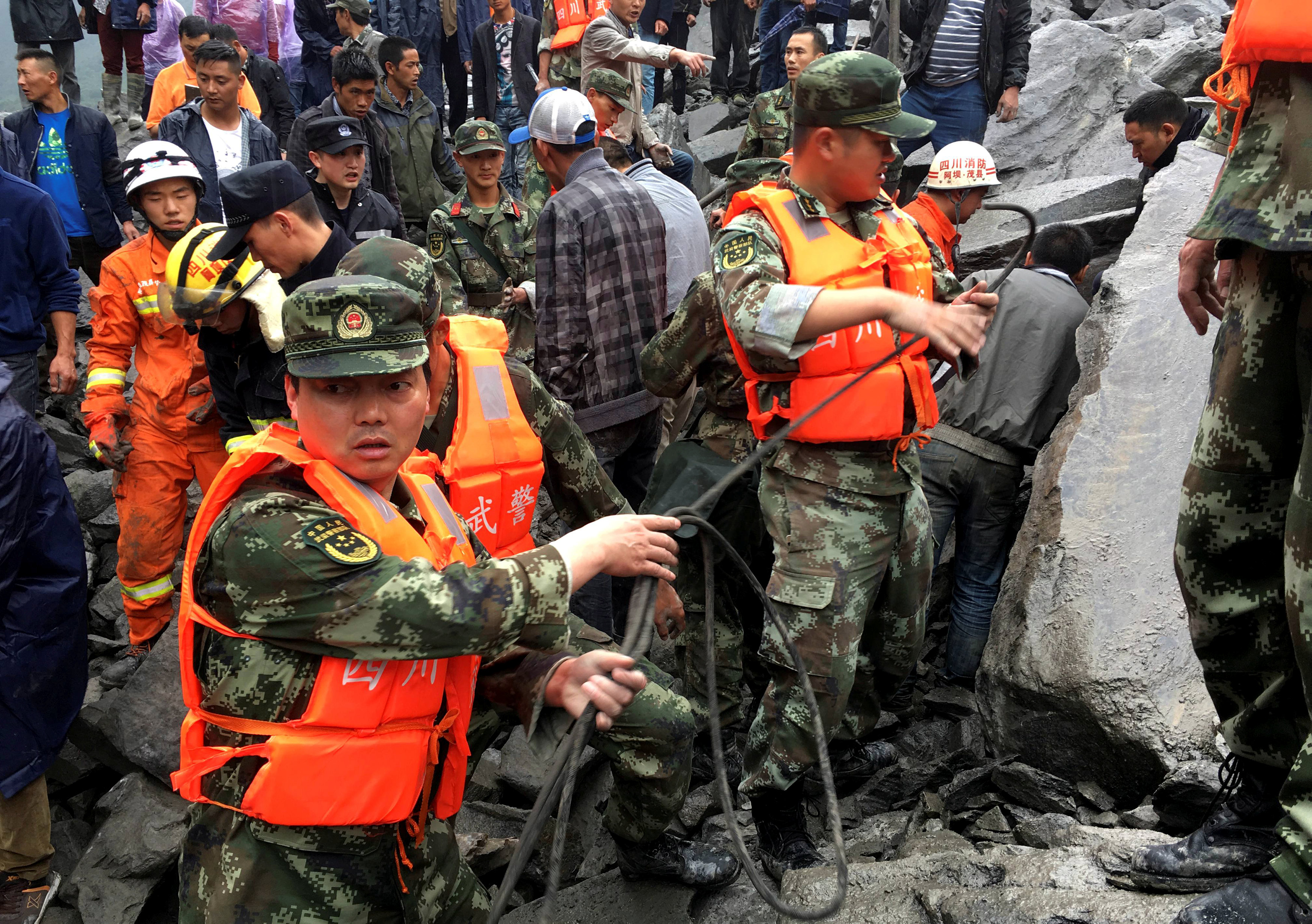 Rescue workers work at the site of a landslide. Photo: Reuters