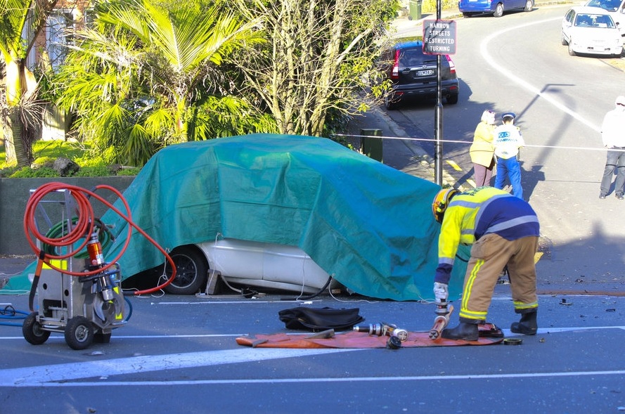 A tarpaulin covers the car at the corner of Mt Eden and Bellevue Rds after the crash. Photo NZ...