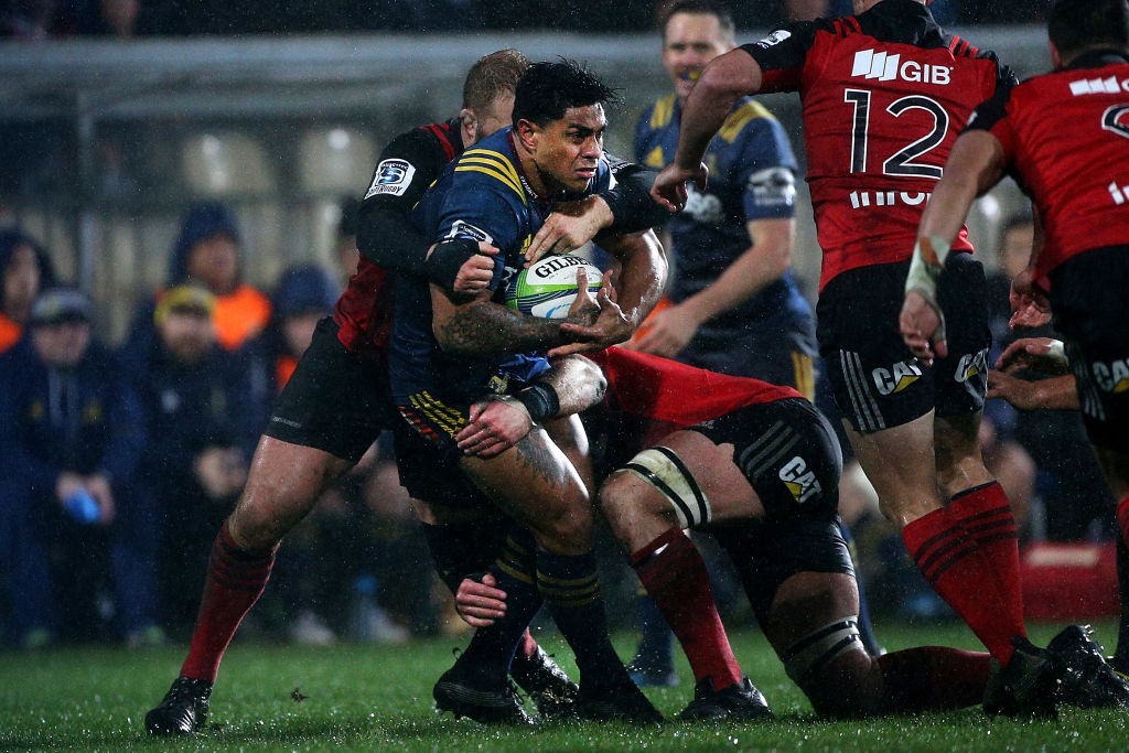 Malakai Fekitoa of the Highlanders tries to break through the tackle of Owen Franks of the...