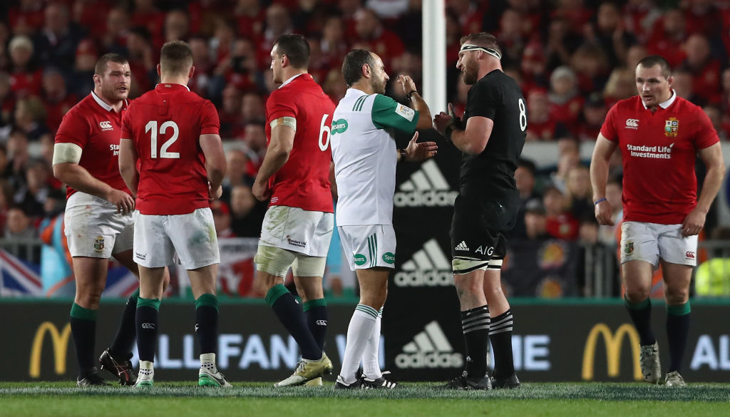 Romain Poite the referee, talks to All Black captain, Kieran Read after he reverses a decision...