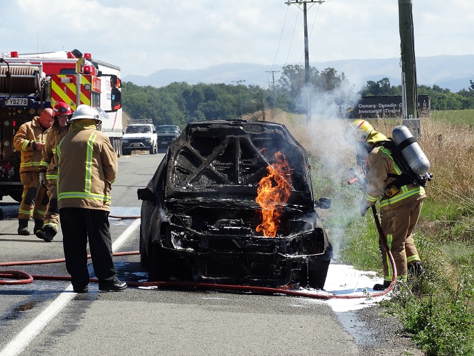 Fire crews were called after this car went up in flames near Oamaru today. Photo Daniel Birchfield