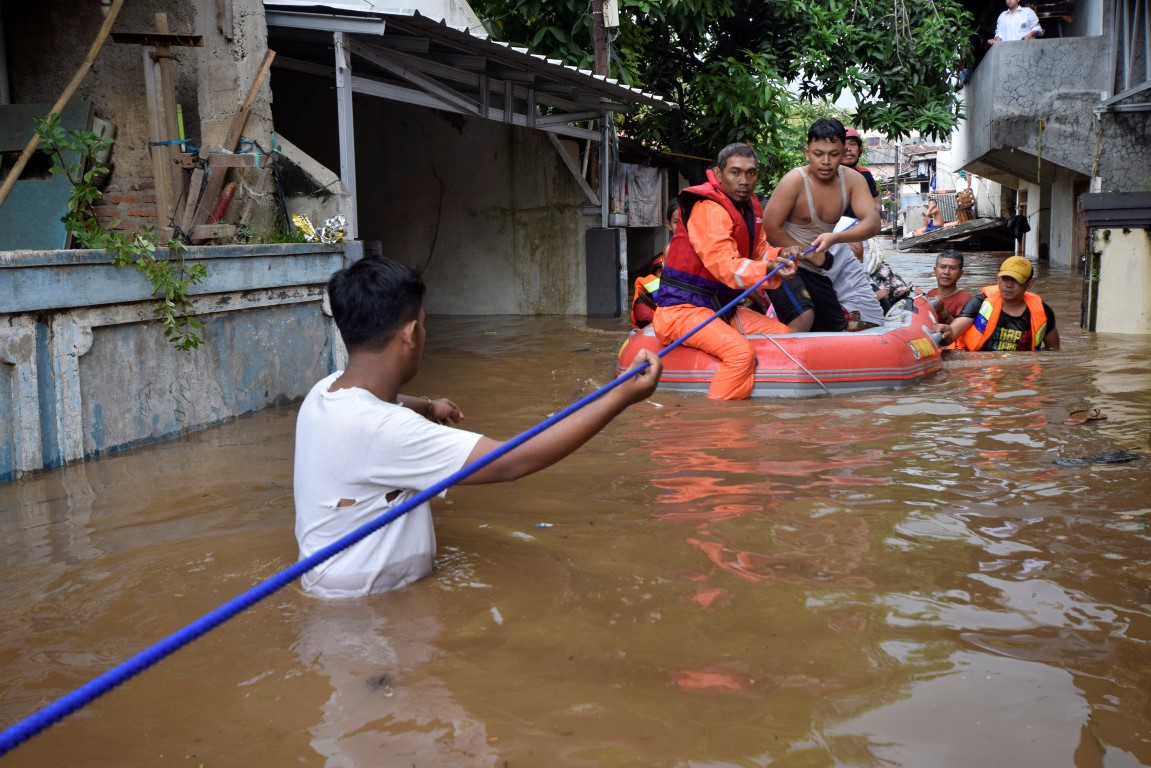 Rescue workers evacuate people from a flooded neighbourhood in Pasar Minggu, South Jakarta Photo:...