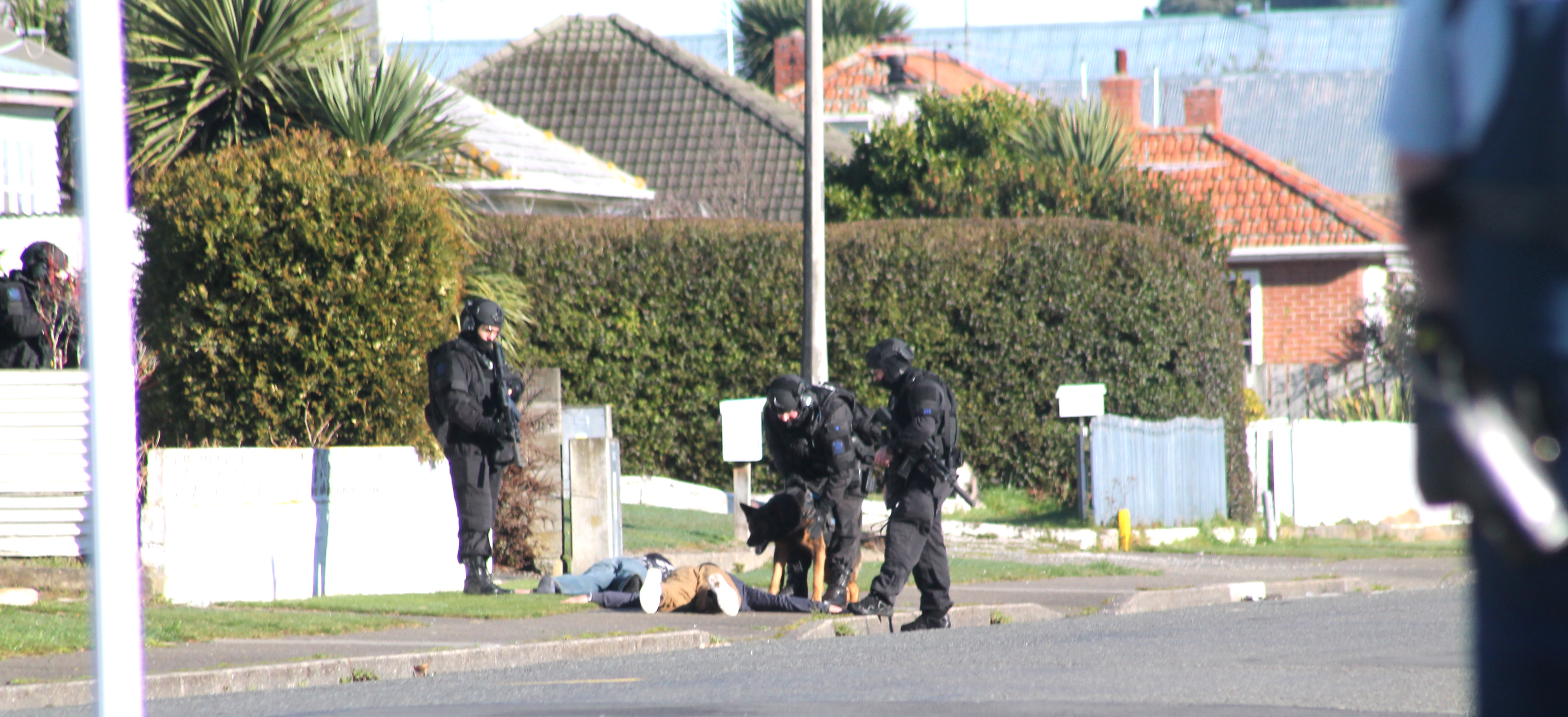 Members of the armed offenders squad deal with two men in Miller St, Invercargill on Monday, when...