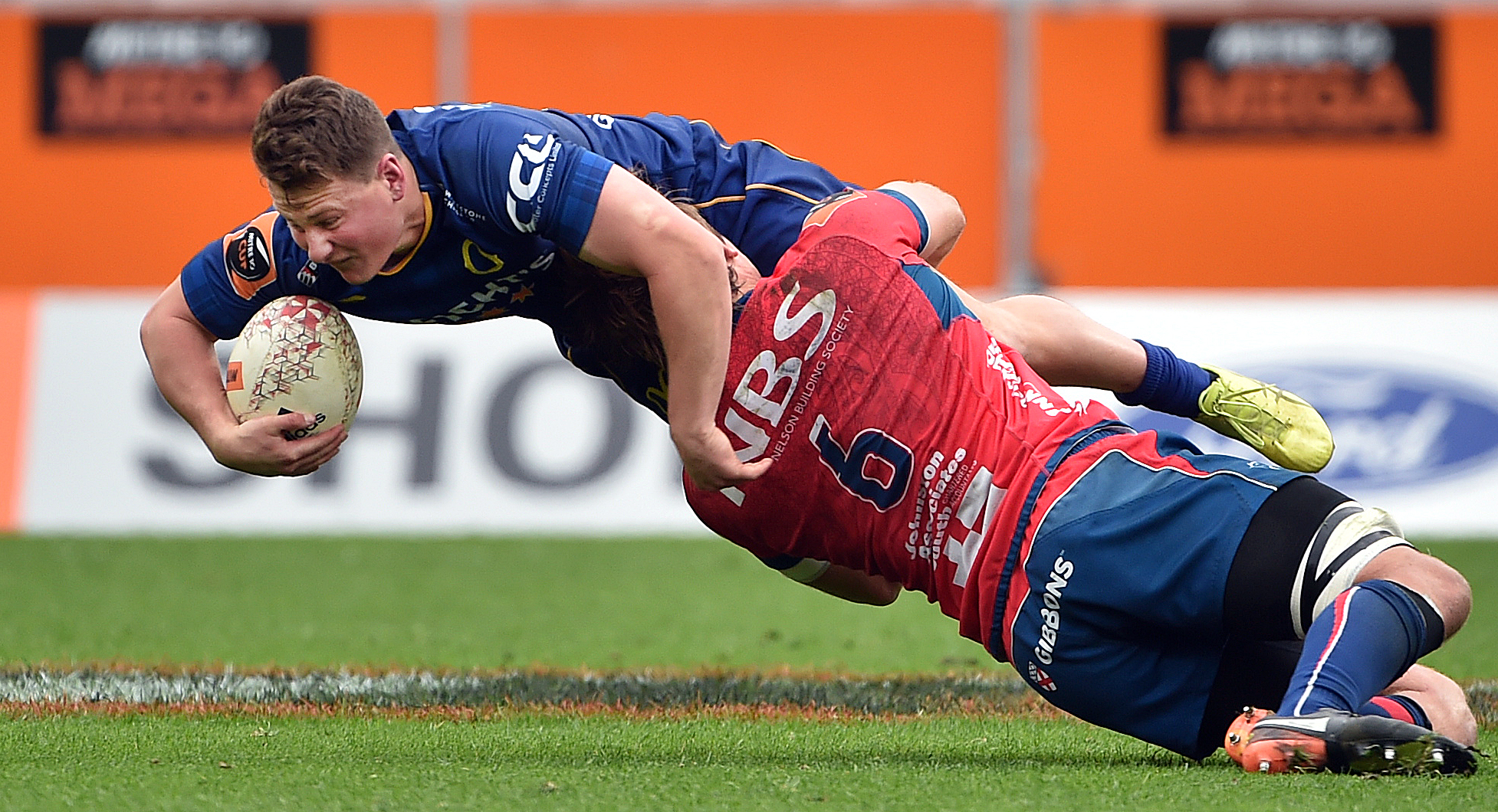 Otago first five-eighth Finn Strawbridge is tackled by Tasman flanker Ethan Blackadder during a...