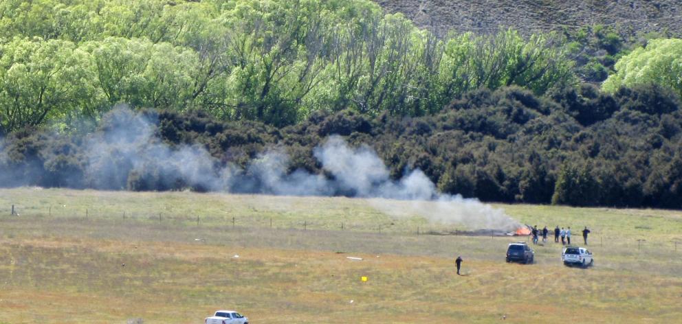 Smoke rises from the wreck of the helicopter crash near Wanaka Airport yesterday. Photo ODT