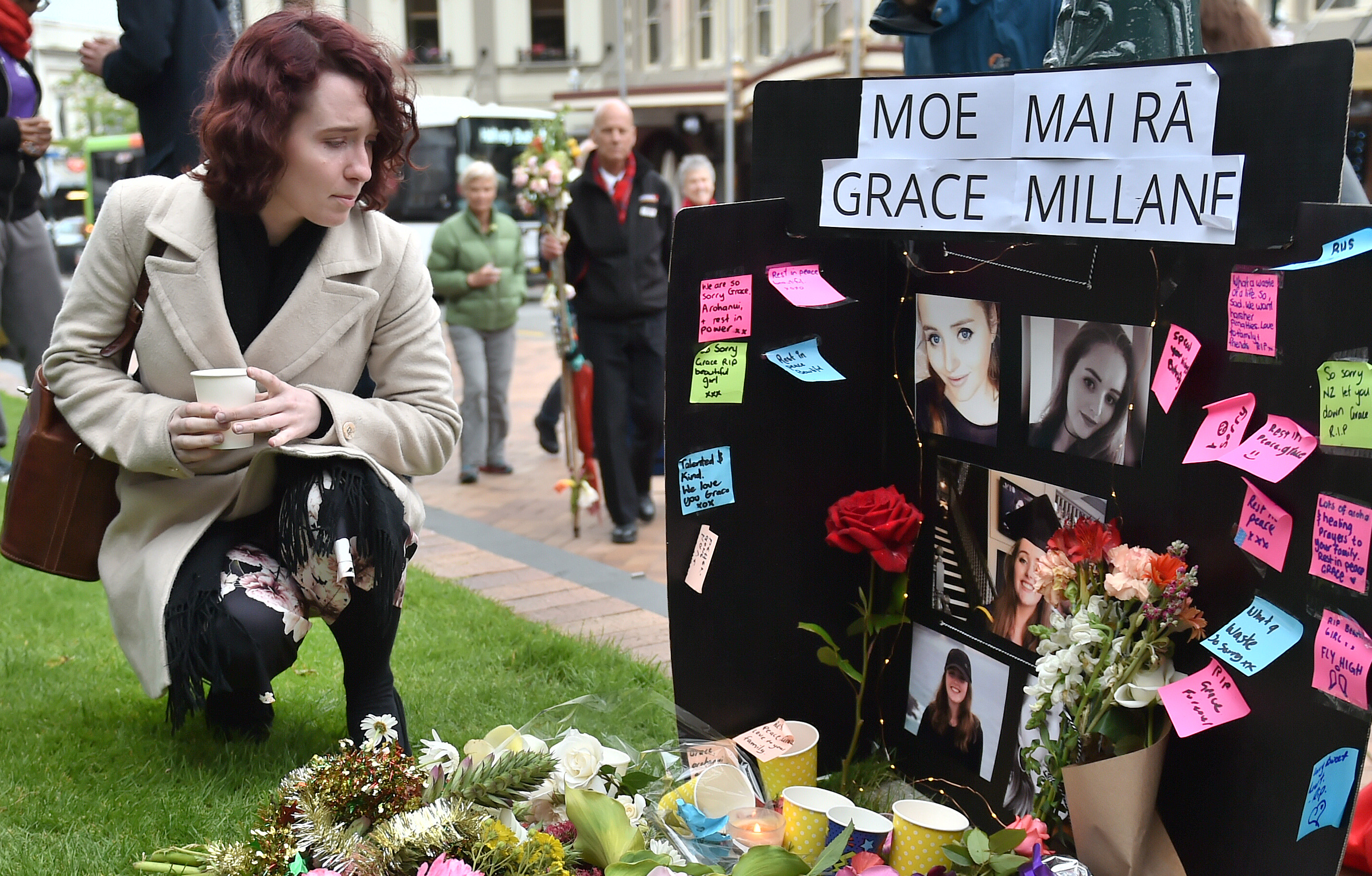 Kerrin Robertson-Scanlon, of Dunedin, pauses as she lays flowers and a candle at a makeshift memorial to Grace Millane in the Octagon last night. Photos: Gregor Richardson