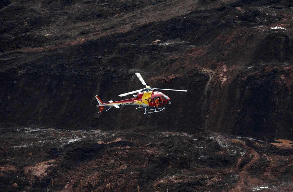 A rescue helicopter flies over the site of the burst dam. Photo: Reuters