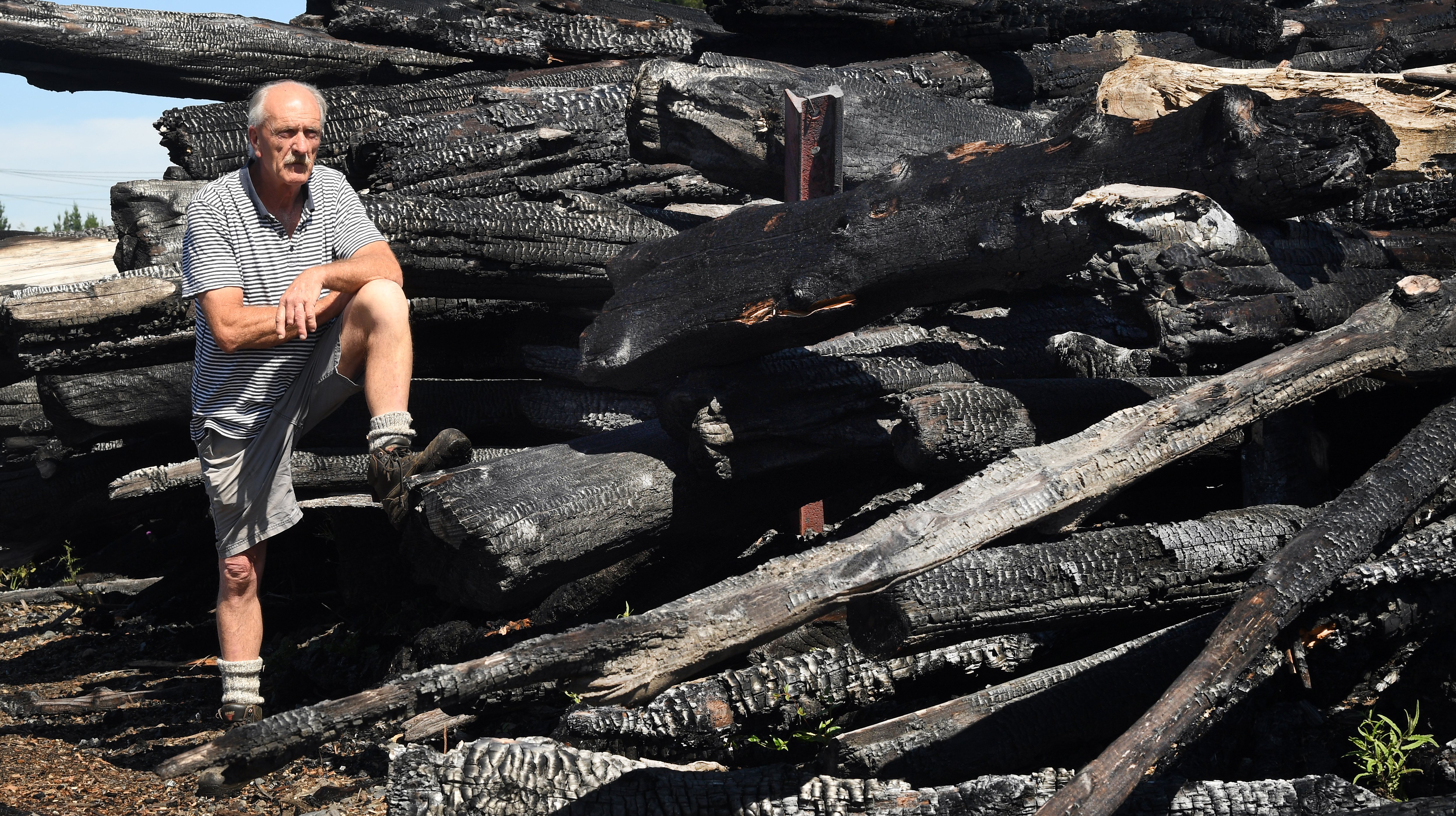 Surveying the charred remains of timber consumed in the Burnside fire is Valley Lumber owner Peter Chalmers. Photos: Stephen Jaquiery