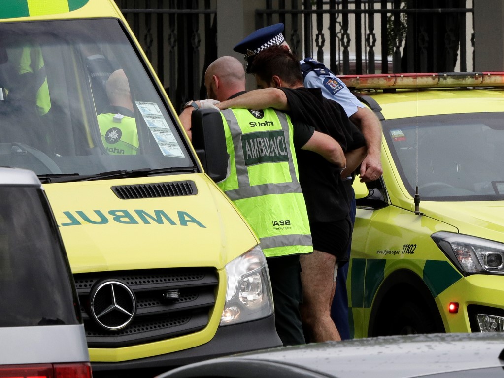 Police and ambulance staff help a wounded man from outside a mosque in central Christchurch....