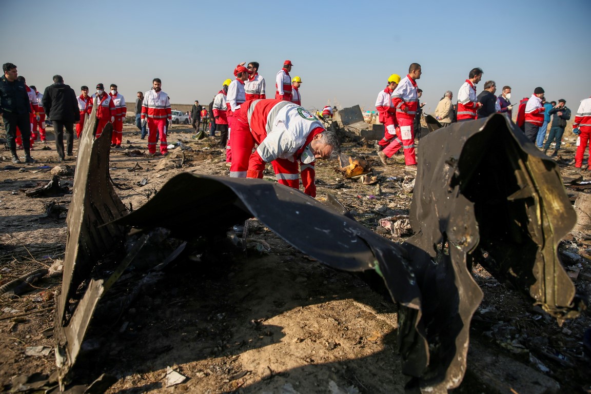 Red Crescent workers check the debris from the crashed plane in the outskirts of Tehran. Photo:...