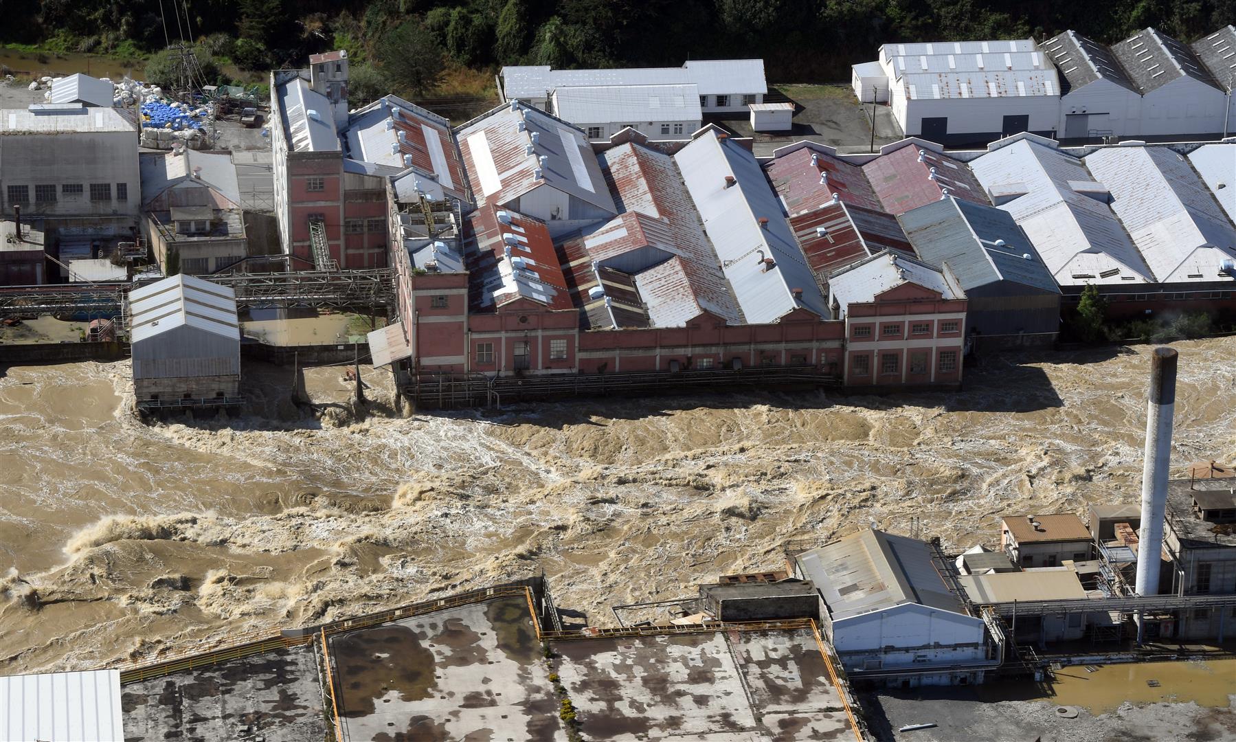 The flooded Mataura River rips past the former Mataura paper mill. Photo: Stephen Jaquiery