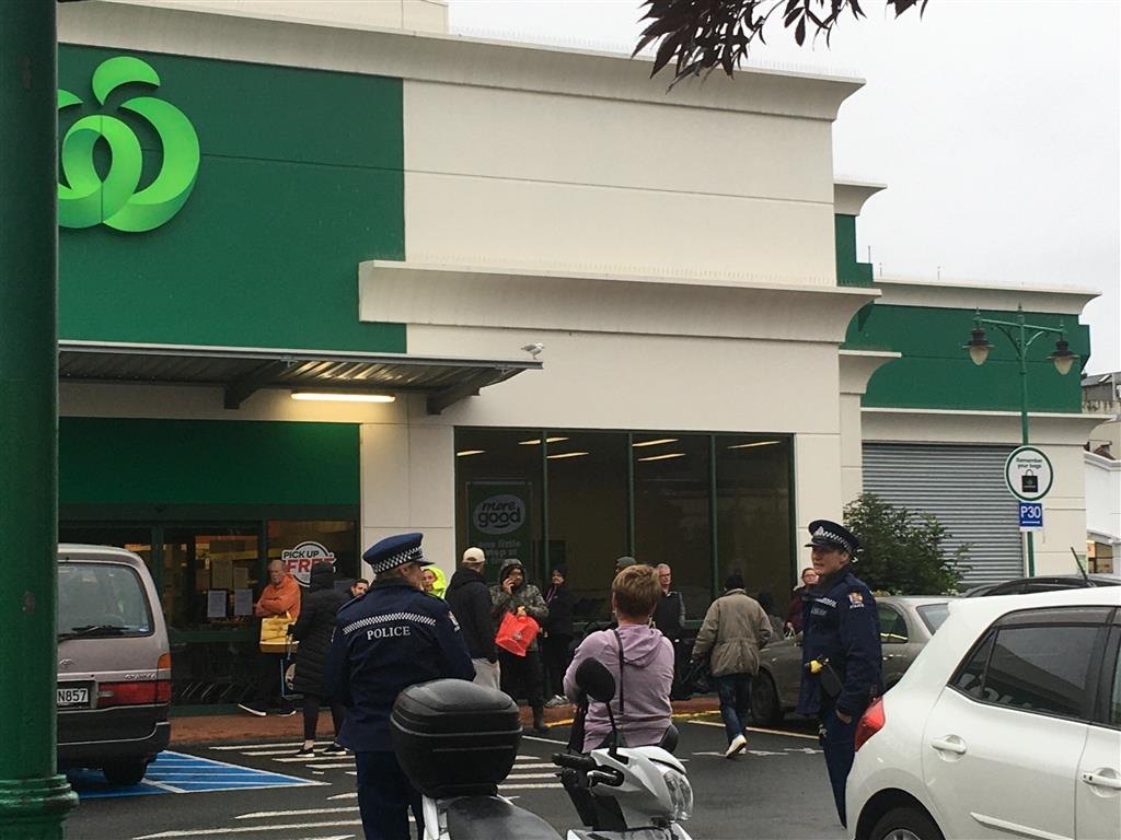 Police keep an eye on shoppers as they wait for Countdown in central Dunedin to open on Tuesday...