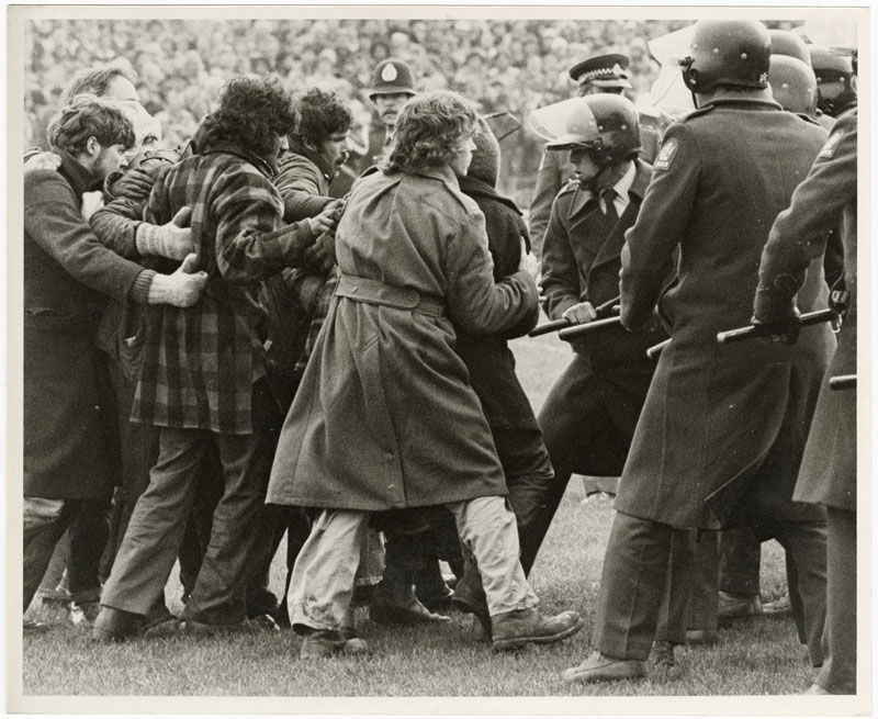 Police in riot gear draw their batons against protesters who invaded the Lancaster Park pitch to...