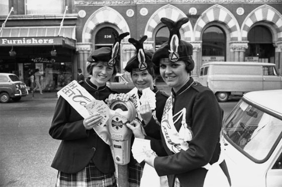 Three girls from the Skellerup Militaries senior marching team with a parking meter on High...