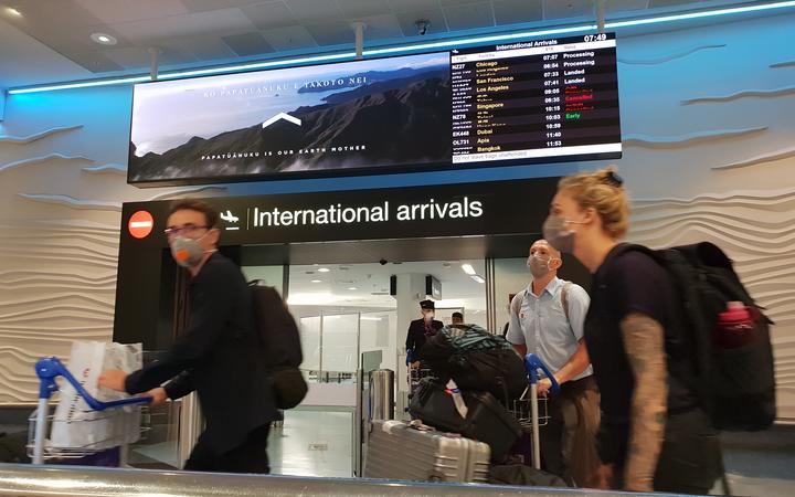 Travellers with face masks at Auckland Airport international arrivals earlier this year. Photo: RNZ 