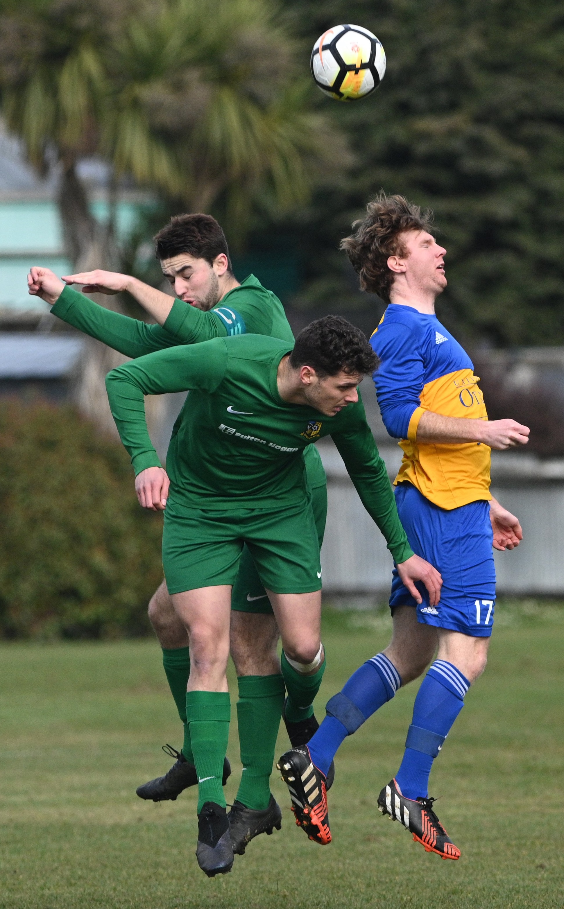 Green Island players Tom Milton (top) and Matt Brazier leap for the ball along with University’s...