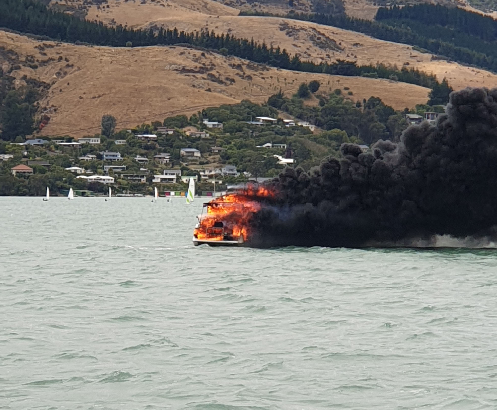 Thick black smoke spread across Lyttelton Harbour after the boat caught fire and sank. Photo:...