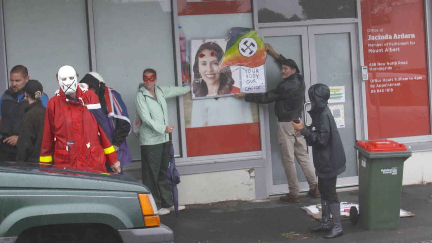 Anti-lockdown protestors gather outside Prime Minister Jacinda Ardern's vacant electorate office...