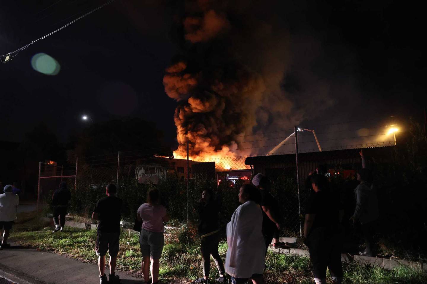 People outside a large fire in Hillsborough, Christchurch. Photo: George Heard