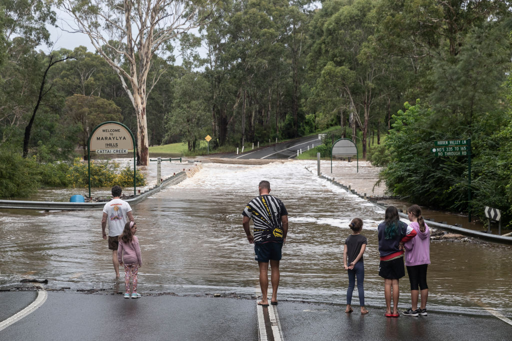 People watch floodwaters rise at Cattai Creek in Maraylya, New South Wales. Photo: Getty