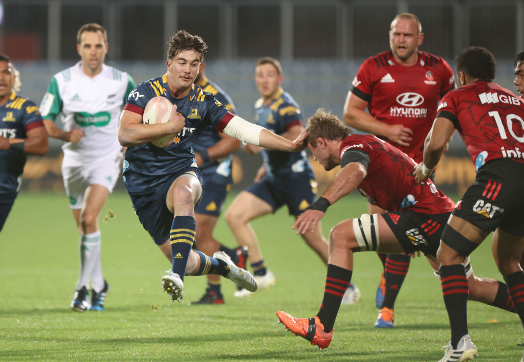 The HIghlanders' Connor Garden-Bachop fends off the Crusaders' Ethan Blackadder.  Photo: Getty