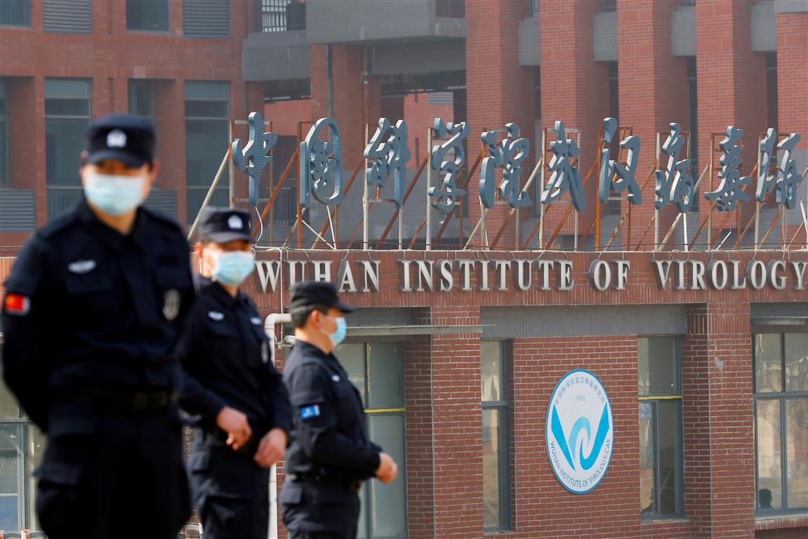 Security personnel keep watch outside the Wuhan Institute of Virology during the visit in...