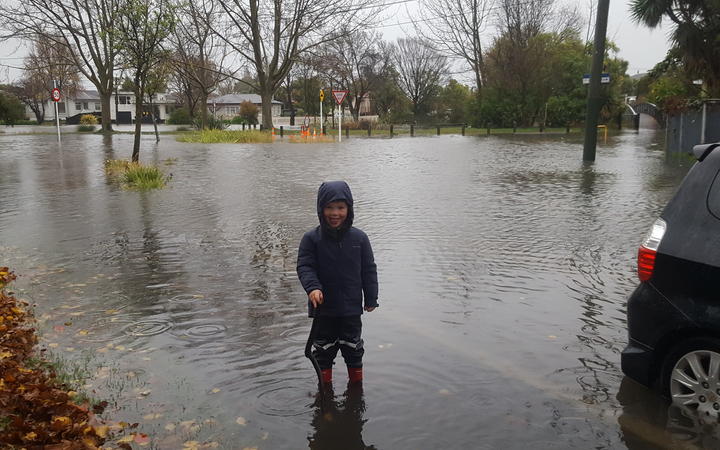 Four-year-old Finn Thorp checks out water levels at the corner of Clarendon Tce and Sheldon St,...