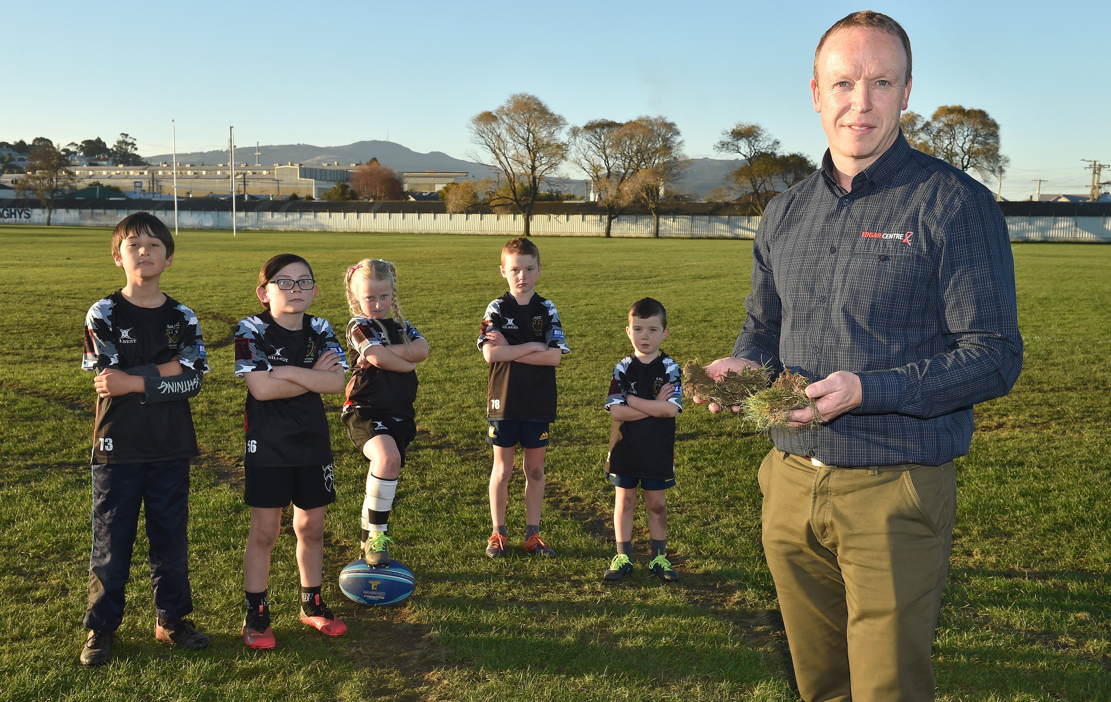 Holding remains of the damaged grounds is Southern Rugby Football Club chairman Blair Crawford (right) and younger members of the club (from left) Lachlan Campbell (8), Hayden Symister (10), Ivy Young (7) and brothers Jordan (8) and Lachie (6) McEwan. PHO