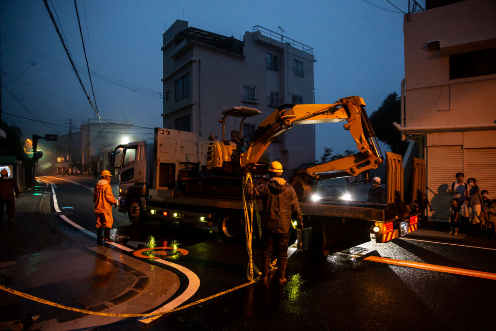 A truck carries an excavator to the landslide site in Atami. Photo: Getty