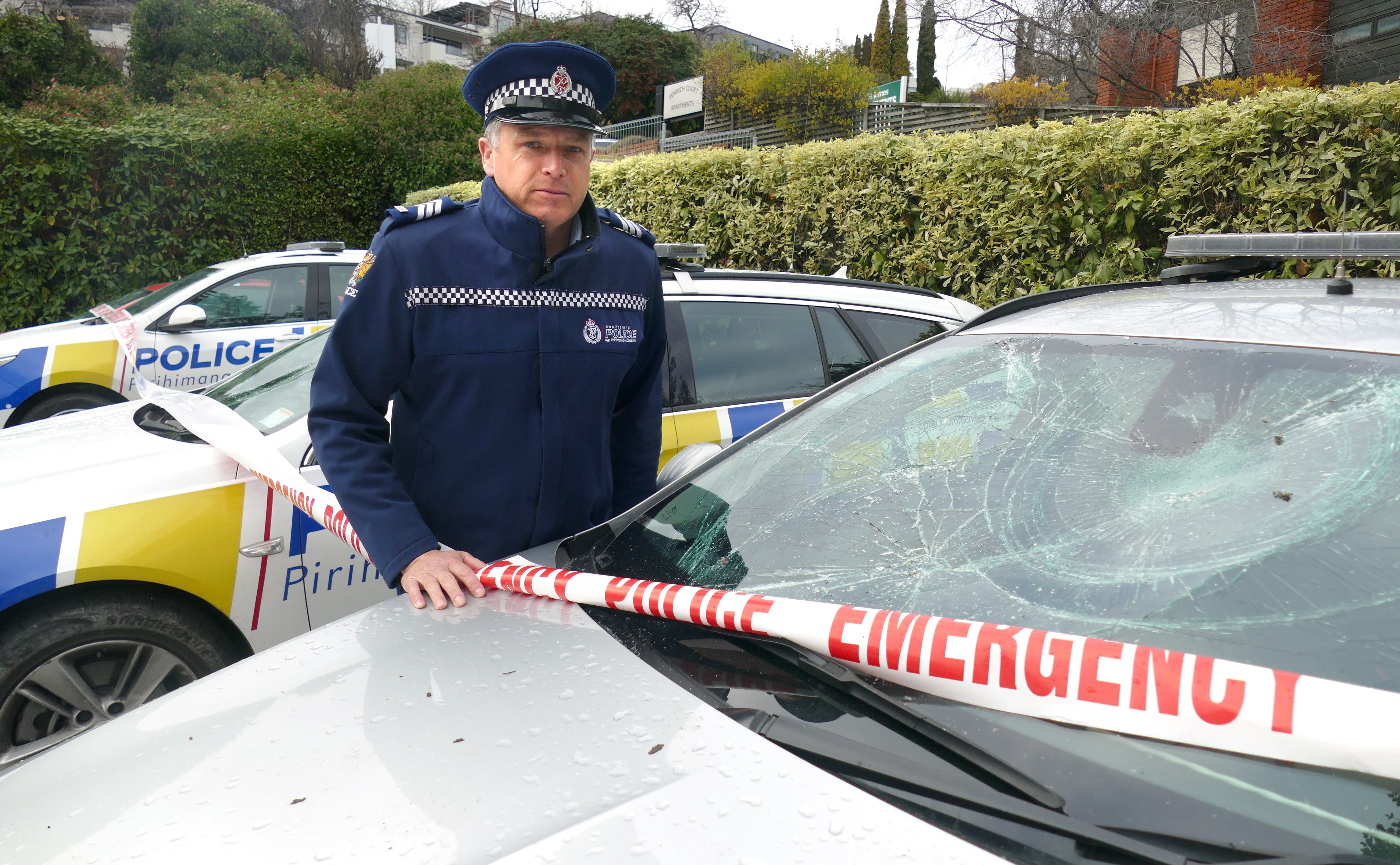 Sergeant Simon Matheson, of Queenstown, inspects some of the police cars damaged at the station...