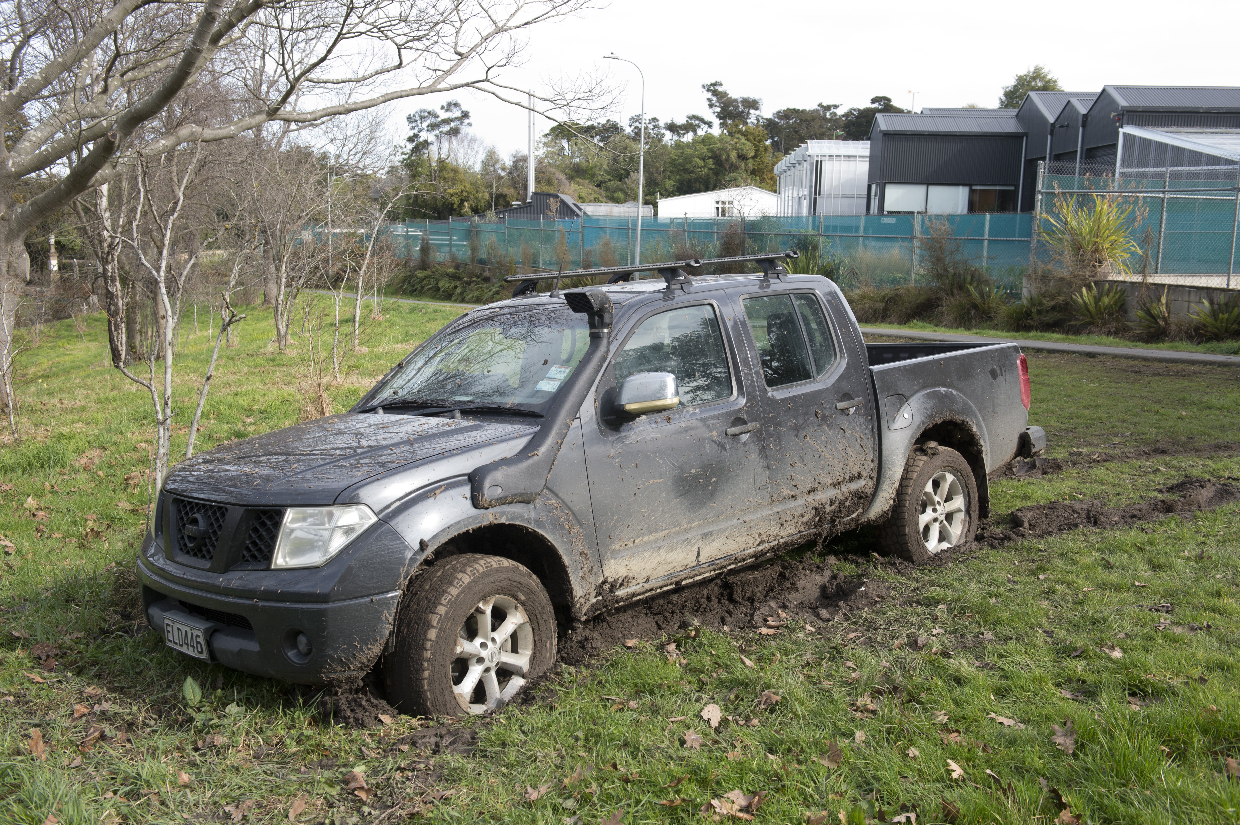 A ute appears to be abandoned after becoming bogged on a grass reserve between the Northern...